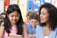 A teacher is working one-on-one with a young girl.